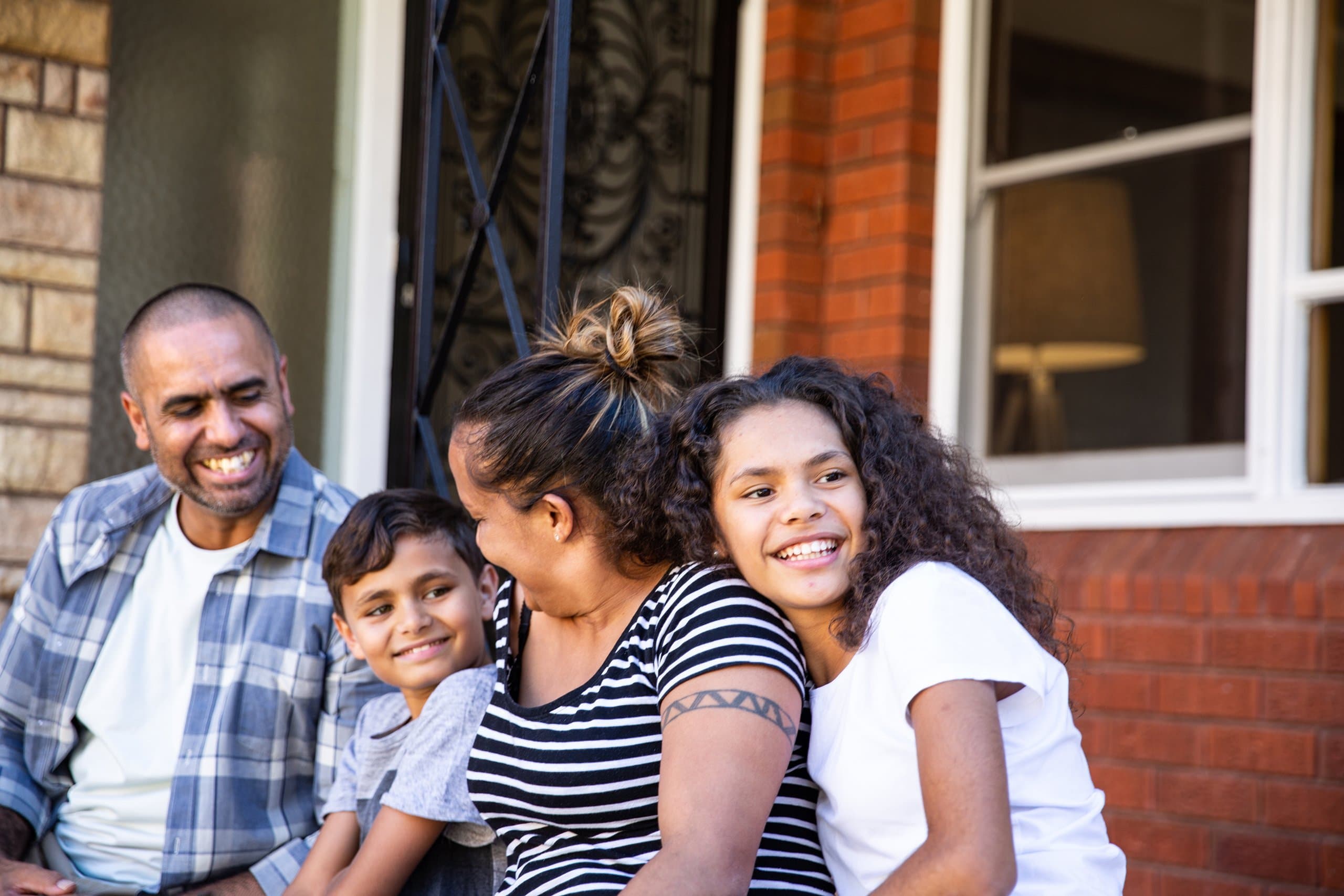 family sits outside home