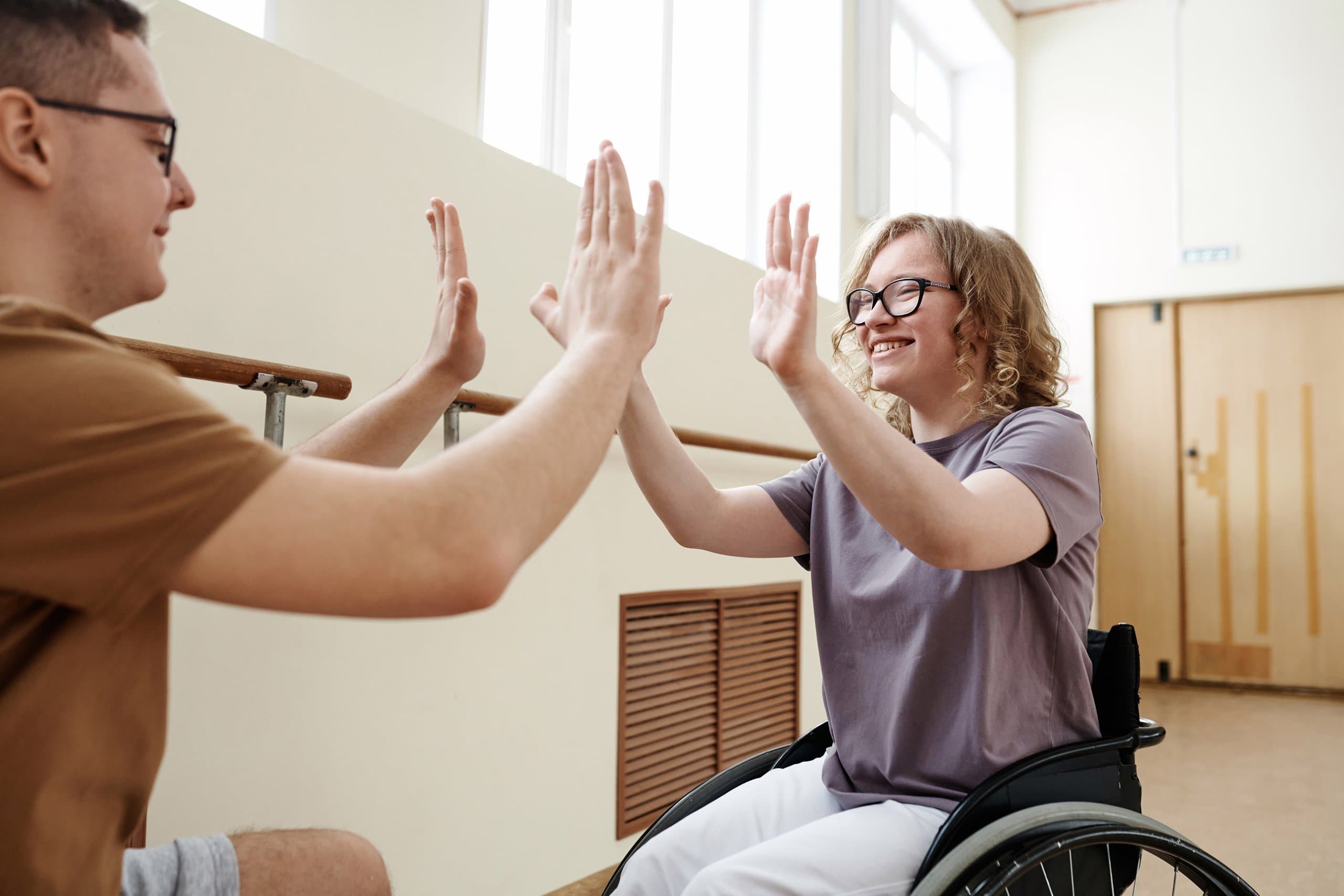 woman in wheelchair high fiving