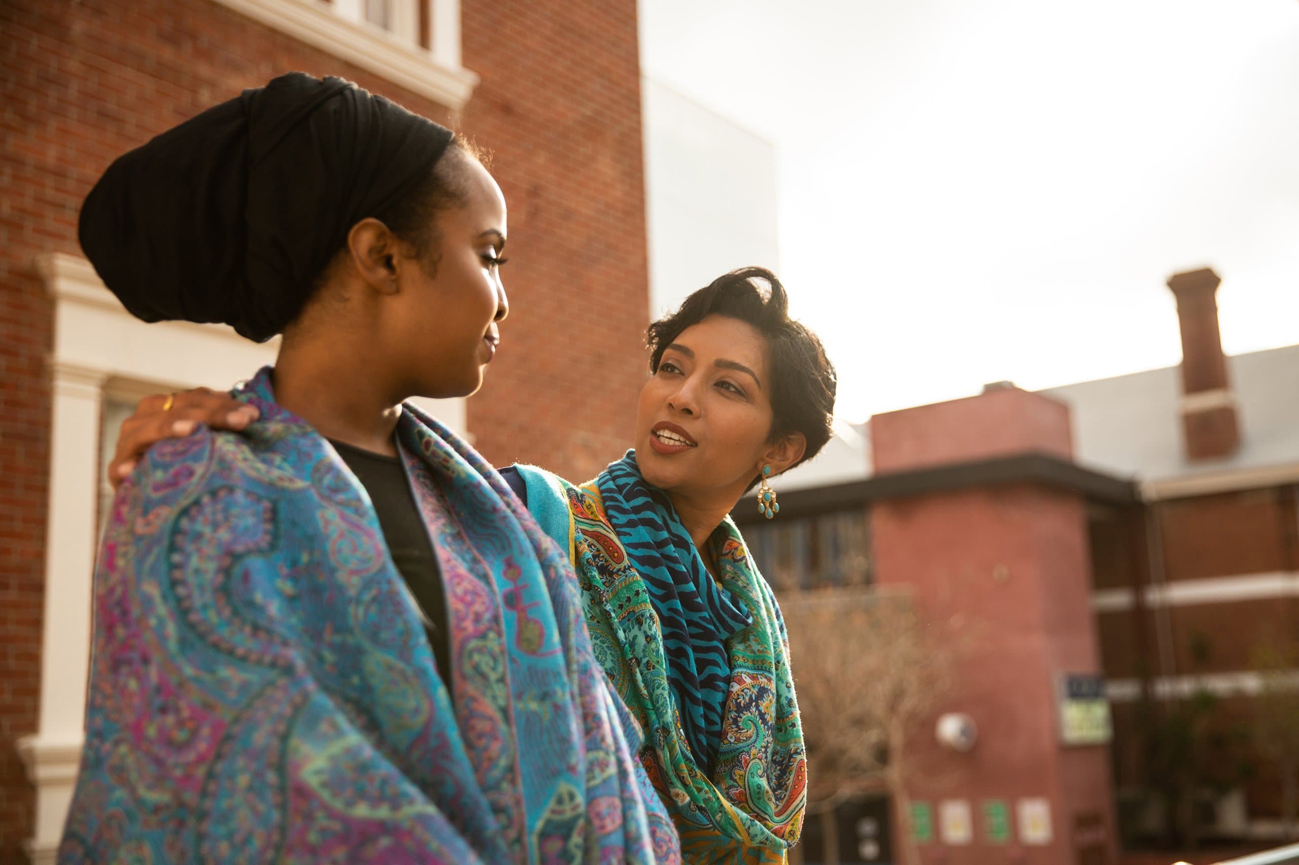 two women talking outside home