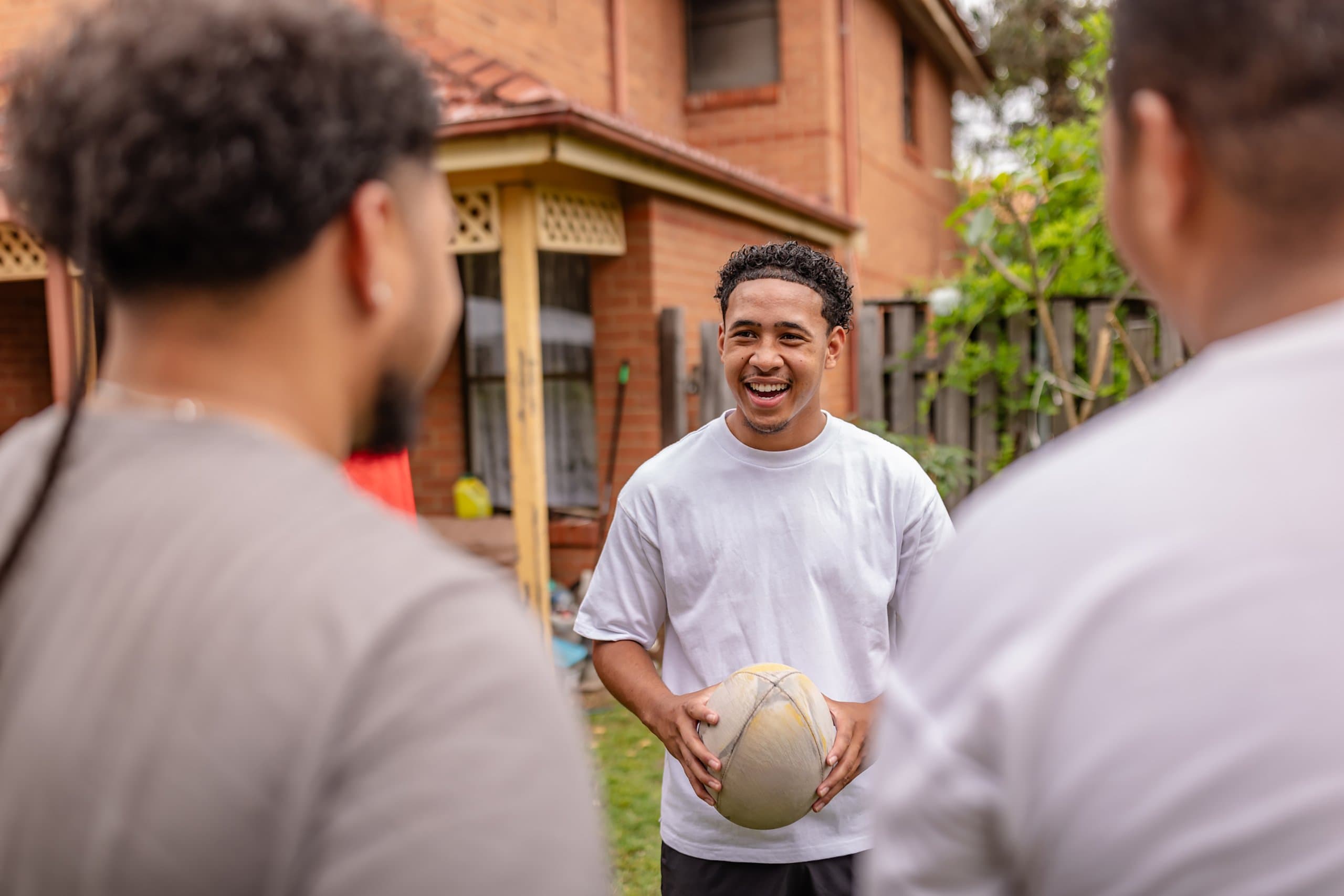 three men outside with a rugby ball